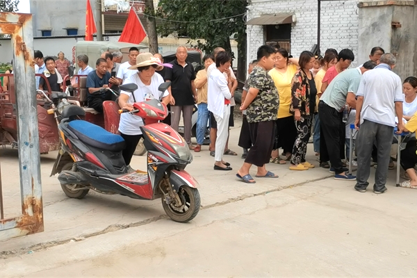 村民們排隊有序領(lǐng)取物資